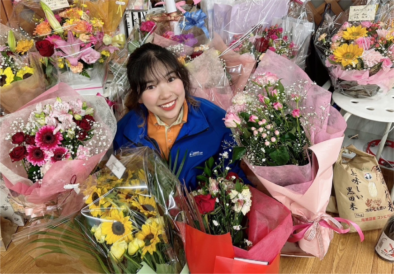 花束に囲まれる女性社員